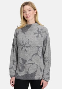Grauer Strickpullover mit floralem Muster in unterschiedlichen Grautönen, hohen Ausschnitt und langen Ärmeln. Weiche Textur und lässige Passform.