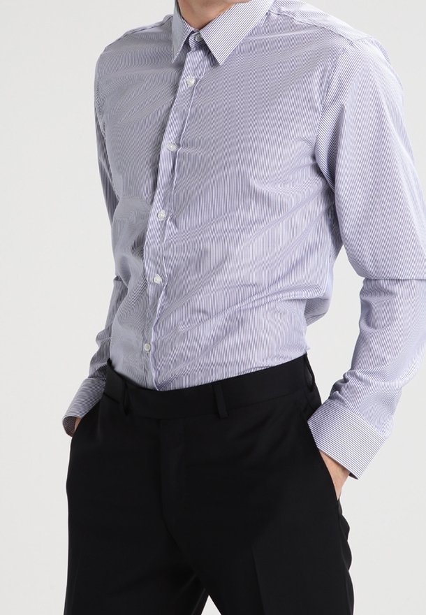 Skjorta med knappar i ljusblå och vita ränder; långärmad, spetsig krage, mjukt tyg, matchad med svarta byxor.