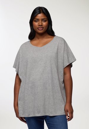 T-shirt grigio, comodo e morbido, con scollatura a V e maniche corte. Realizzato in un tessuto soffice con una leggera trama. Abbinato a jeans blu.