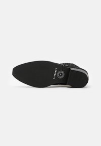 Suela de zapato negra con goma texturizada y ranuras horizontales, marcada con "PAYEMENT" y un logotipo circular cerca del talón.