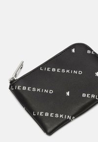 Czarny skórzany portfel z białym napisem, na którym widnieje "LIEBESKIND" oraz "BERLIN". Posiada srebrny zamek błyskawiczny i gładką teksturę.