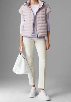 Lichtpaarse puffer vest met capuchon over een gestreept lavendel langemouwen shirt, gecombineerd met witte slim-fit broek en witte sneakers. Witte handtas inbegrepen.
