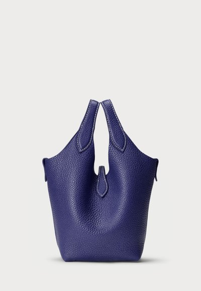 Violeta ādas rokassoma ar teksturētu virsmu, divām īsām rokturiem un asimetrisku atvēršanu. Nav redzamu mehānismu vai rakstu.