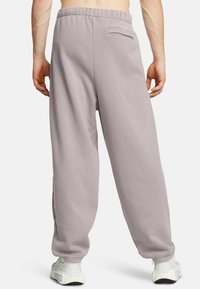 Ljusgrå sweatpants med avslappnad passform, elastisk midja och detalj med bakficka. Mjuk bomullstyg med en slät yta.