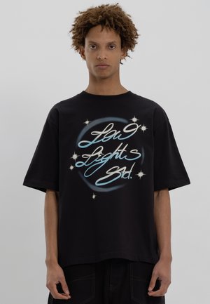 T-shirt noir surdimensionné en coton avec un motif graffiti bleu et blanc comprenant des étoiles et le texte "Lou Lights Std."