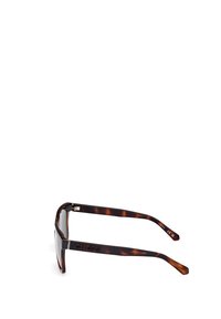 Lunettes de soleil en écaille de tortue avec une monture rectangulaire, accentuées par un logo "GUESS" sur la branche. Elles possèdent des verres transparents et une finition lisse.