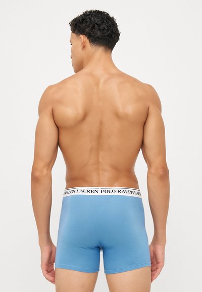 Boxeri scurți de culoare albastru deschis, fabricați din bumbac. Dispune de un elastic cu logo în alb și negru. Textură netedă cu un design ajustat. Fără modele vizibile.