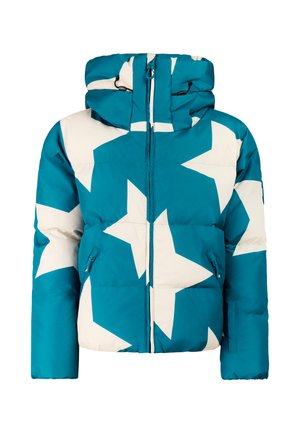 Kind draagt een blauwe jas met sterrenpatroon, zwarte sneeuwbroek, zwarte helm en laarzen, staat met de handen in de jaszakken.