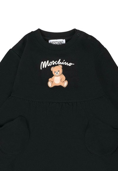 Czarna bluza z okrągłym dekoltem, graficznym nadrukiem w postaci rysunkowego misia oraz kieszeniami bocznymi o zaokrąglonych krawędziach. Logo "Moschino" na górze.
