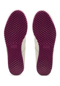 Bílé tenisky s texturovanou fialovou gumovou podešví. Obsahují tkaný diamantový vzor pro lepší přilnavost a logo vyražené na klenbě.