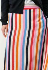 Gonna maxi a righe con linee verticali in arancione, rosa, blu, nero e crema. Tessuto morbido con un design fluido, elastico in un colore contrastante.
