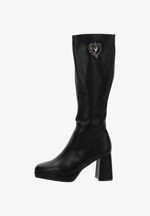Bottes noires jusqu'aux genoux en cuir lisse, dotées d'un talon carré et d'un ornement argenté en forme de cœur sur le côté extérieur.