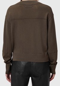 Brązowy dziergany sweter z okrągłym dekoltem i opuszczonymi ramionami, z prążkowanym dołem i miękką fakturą, zestawiony z czarnymi skórzanymi spodniami.