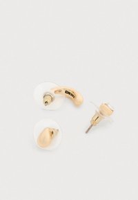 Σκουλαρίκια σε χρυσό χρώμα με διάφανο πλαστικό πίσω μέρος· το ένα έχει σχήμα σταγόνας, ενώ το άλλο στρογγυλό σχέδιο με διαυγή διακοσμητική πέτρα.