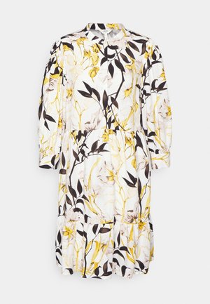 Vestido midi de manga larga blanco con un patrón floral en amarillo y negro, cintura fruncida y dobladillo con volantes.