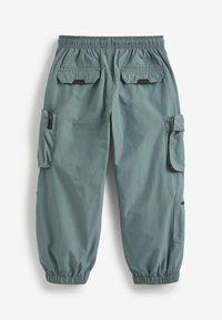 Pantalons cargo en teal délavé, légers, avec taille élastique, poignets froncés, deux poches latérales et deux poches arrière à rabat. Tissu résistant à l'abrasion.