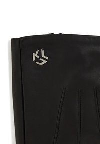 Must musta kinnas, millel on õmblustega detailid ja hõbedane logo aktsent. Sile tekstuur ja sobiv kuju kindla kandmise tagamiseks.