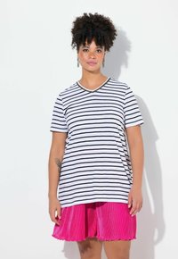 Stribet bomulds t-shirt i hvid og sort, v-hals med perle detaljer, sat sammen med en lys pink plisseret nederdel med bølgede kanter.