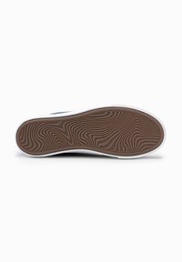 Suela de goma con una textura ondulada en marrón y blanco. Presenta un patrón estriado y antideslizante para proporcionar tracción. Diseño minimalista y aerodinámico.