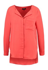 Korallenfarbige Bluse mit langen Ärmeln aus glattem Stoff, mit V-Ausschnitt, einer einzelnen Brusttasche und einem abgerundeten Saum, der hinten etwas länger ist.