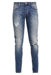 Tight slim fit blå denimjeans med blekning, slitna detaljer och rivningar vid knäna. Har klassisk femficksdesign och gyllene detaljer.