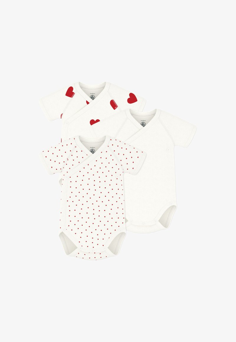 Trzy białe body niemowlęce z krótkim rękawem; jedno gładkie, jedno z małymi czerwonymi serduszkami, oraz jedno z dużymi czerwonymi serduszkami na ramionach.