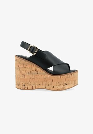 Schwarze Leder-Wedgesandalen mit Korkplattform, offenes Design, verstellbarer Knöchelriemen mit goldener Schnalle, strukturierte Korkdetails.
