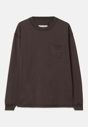 T-shirt en coton marron foncé à manches longues. Il présente un col rond et une poche sur la poitrine gauche avec des détails embossés subtils. Design simple.