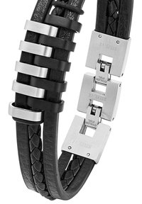 Pulsera de cuero negro con tiras trenzadas y lisas, que presenta acentos rectangulares de acero inoxidable y un cierre de metal.
