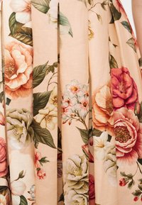 Υφασμα με λουλούδια, με μεγάλα ροζ, λευκά και ροδακινί άνθη και πράσινα φύλλα σε απαλό μπεζ ριγωτό φόντο.