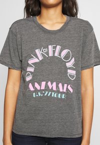 Szara bawełniana koszulka z krótkim rękawem z wielokolorowym wzorem graficznym z napisem "Pink Floyd Animals U.S. '77 Tour" w kolorze różowym i niebieskim.