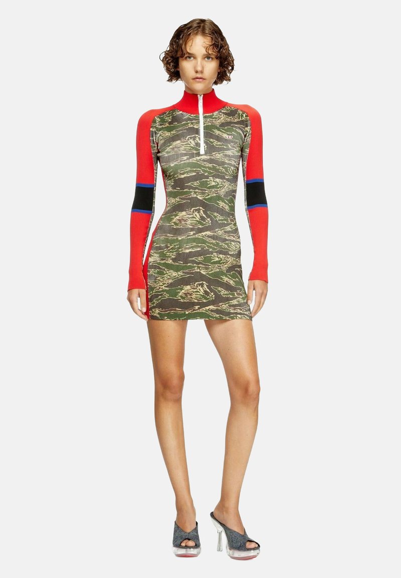 Abito con motivo mimetico dalla silhouette aderente, collo alto rosso e maniche lunghe. Presenta una zip frontale e una texture a coste.