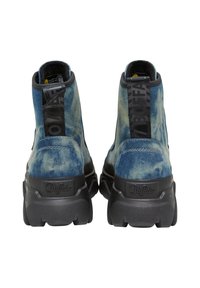 Stivaletti alla caviglia in denim blu con suola nera spessa, caratterizzati da una finitura testurizzata, un tab per il pull e un logo distintivo sul retro.