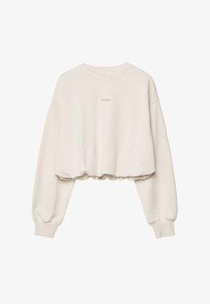Krämfärgad kort sweatshirt med långa ärmar och "studio" tryckt med små svarta bokstäver på bröstet.
