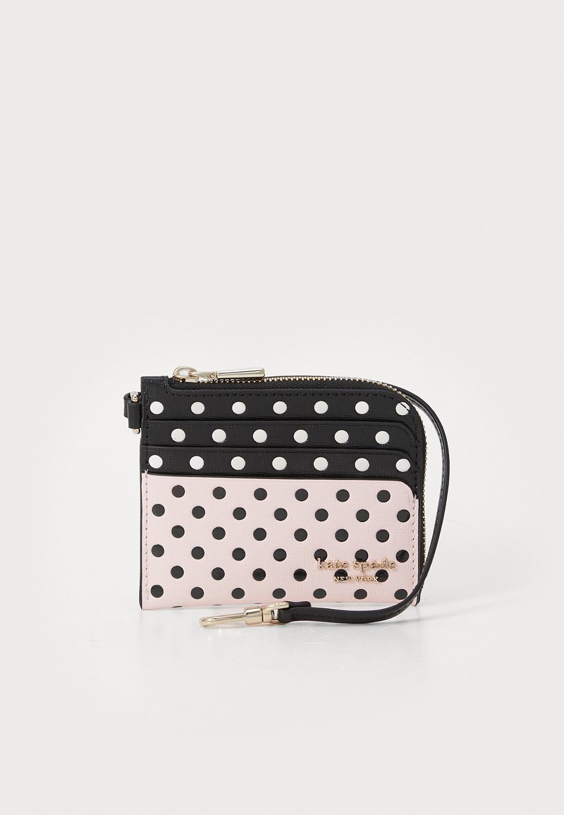 Wallet featuring a black and pink polka dot pattern, textured materials, a zip closure, and gold-tone hardware with a wrist strap.