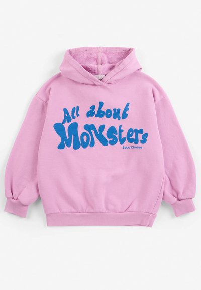 Sweat à capuche rose avec texte bleu indiquant "All about Monsters" et petit nom de marque "Bobo Choses" à l'avant.