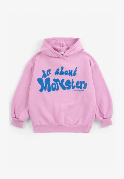 Sweat à capuche rose avec texte bleu indiquant "All about Monsters" et petit nom de marque "Bobo Choses" à l'avant.
