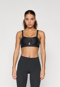 Sutien sport negru cu bretele reglabile și o textură netedă. Prezintă un logo subtil în centru și o croială clasică pentru suport.