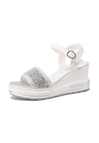 Sandali wedges bianchi con una larga fascia argentata scintillante, cinturino alla caviglia regolabile e una suola grigia texturizzata.