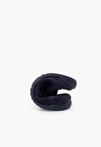 Chaussure à enfiler bleu marine avec un design flexible, une doublure intérieure douce et une semelle en caoutchouc texturée pour une meilleure adhérence, présentée en position pliée.