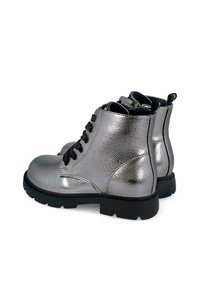 Botas tobilleras metálicas plateadas con un acabado texturizado, cordones negros y una suela robusta. Cuentan con una lengüeta para facilitar su uso.