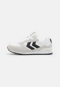 Vit och grå sneaker med meshnästan, mockadetaljer och svart chevrondesign. Har vita snören och en svart gummisula.