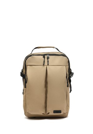 Mochila rectangular beige con dos bolsillos frontales con cremallera, asa superior, hebillas laterales y tiradores de cremallera negros.