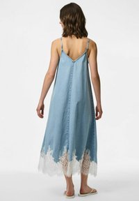 Denim kleita ar spaghetti palīdzēm, A veida siluets, gaiši zila auduma, ar baltu mežģīņu apakšmali un brīvu piegriezumu.