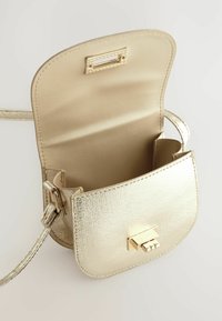 Guld metallisk crossbody taske med et strømlinet design, der har en flaplukning og en glat overflade. Indersiden inkluderer to rum og en lille lomme.