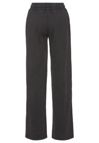 Zwarte katoenen joggingsbroek met een ontspannen pasvorm, voorzien van een elastische tailleband, wijde pijpen en een subtiele textuur, ontworpen voor comfort.