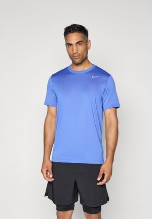 T-shirt de sport bleu Nike avec col rond, manches courtes et un design en dégradé subtil ; associé à un short noir avec fentes latérales.