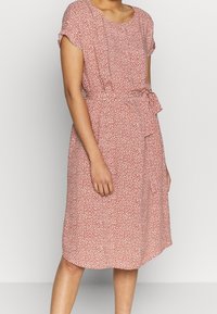 Vestido de estampado floral rojo con mangas cortas, cuello redondo y detalle de cintura anudada. Fabricado con tejido liviano; corte a media longitud.