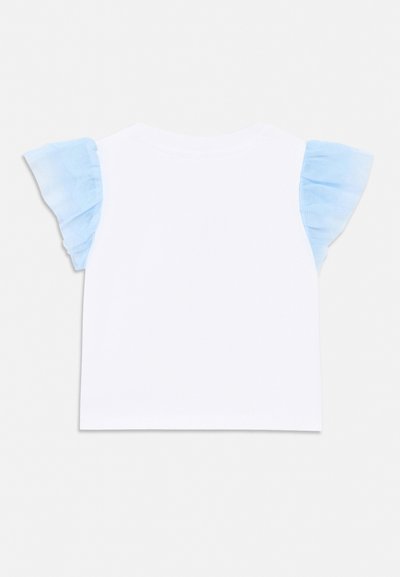 Haut blanc à manches courtes avec des détails en tulle bleu clair à volants sur les épaules, vu de dos.