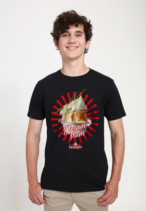 Sort t-shirt med grafik af ost på en brødbolle, røde solstråler og teksten "Dream Team" ovenfor og "boursin" nedenfor.